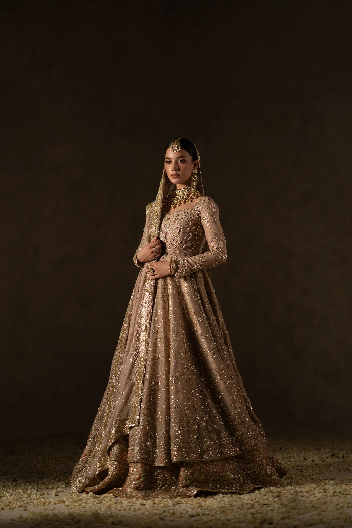 fawn pink Pishwas bridal dress with lehenga meticulously adorned with intricate thread work, zardozi, gota, sequins, and mokaish.